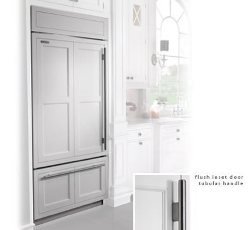 Built in refrigerator with a framed cabinet style overlay and applied handles