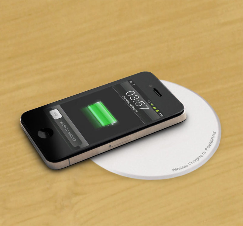 Detail view of the wireless charging mat in the center of the table with a phone charging