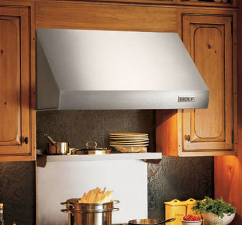 Wall mounted hood over a cooking range in a kitchen
